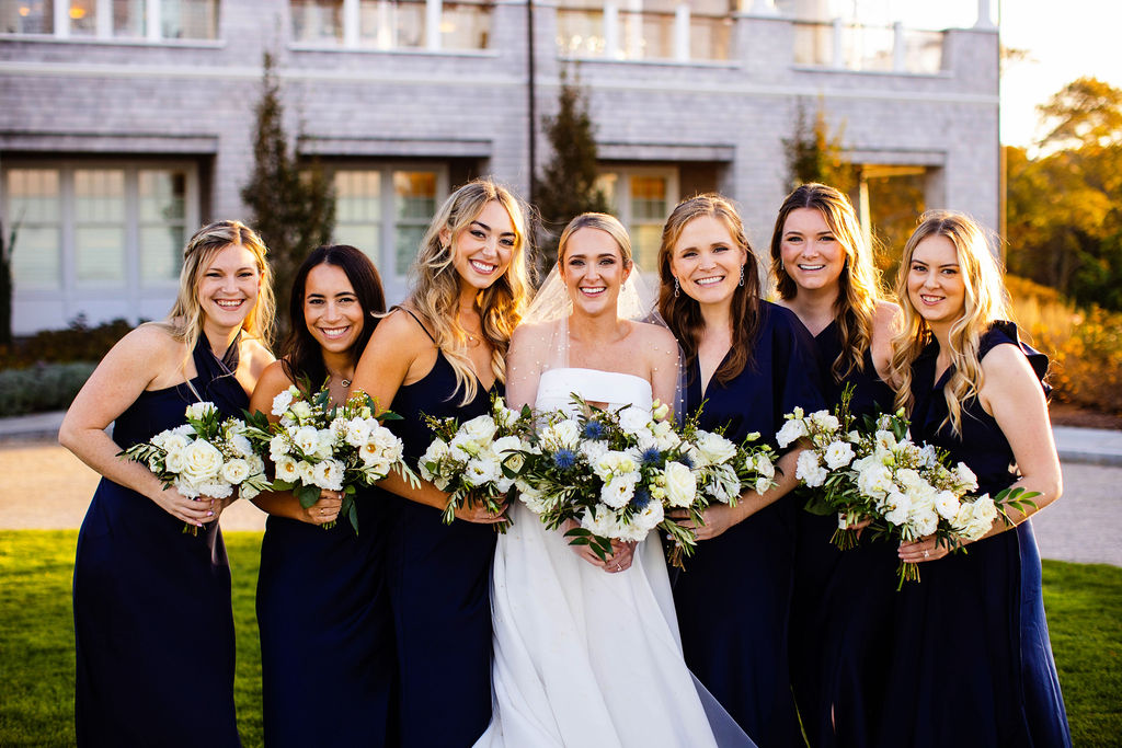 Bride and her bridesmaids pose in front of Woods Hole Golf Club in Cape Cod