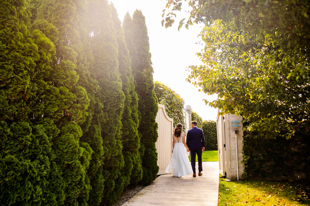 Bride and groom walking through the gates to the salon at Belle Mer for their wedding in Newport