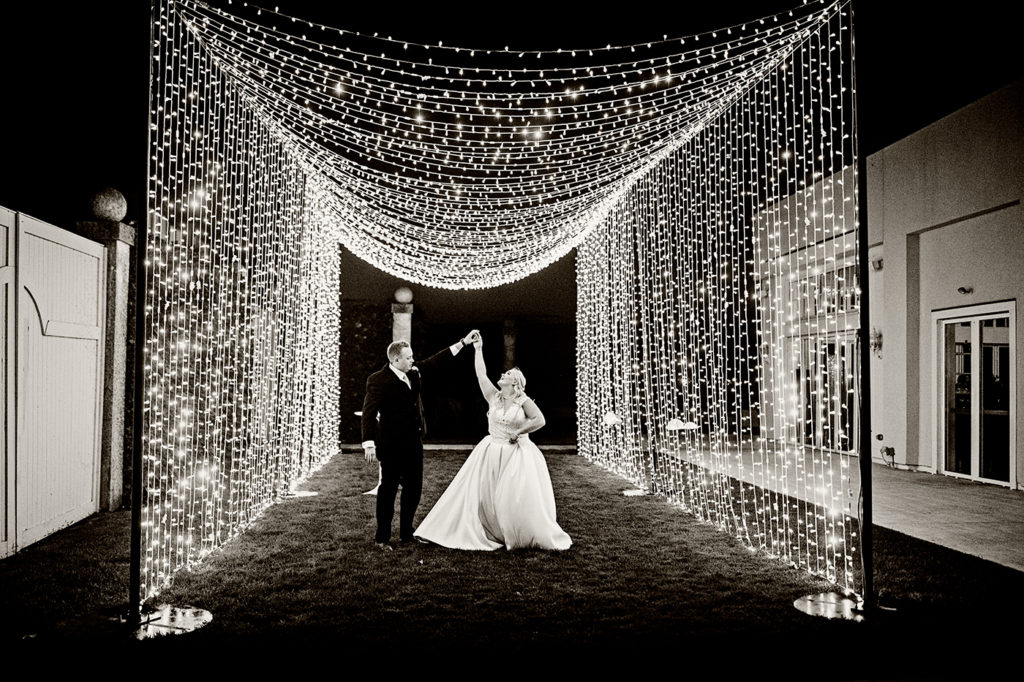 Bride and Groom under custom light installation set up at their Belle Mer Wedding in Newport, RI.