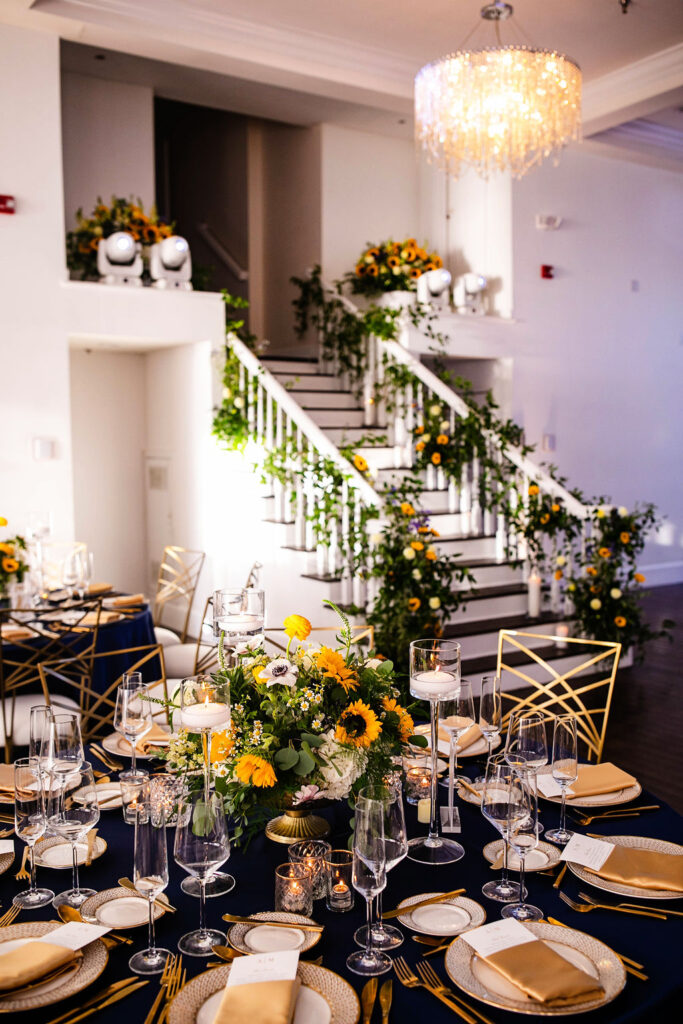 Reception space with sunflowers, navy blue linens, and gold accents at Belle Mer wedding in Newport, RI 