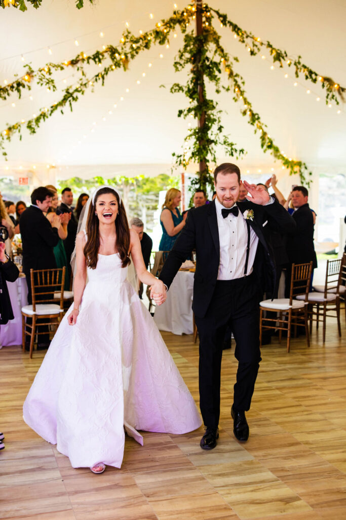 Bride and Groom entering reception tent with ratan lanterns and greenery at Mount Hope Farm wedding