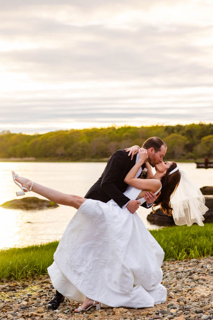 Bride and Groom by the water at sunset at Mount Hope Farm wedding