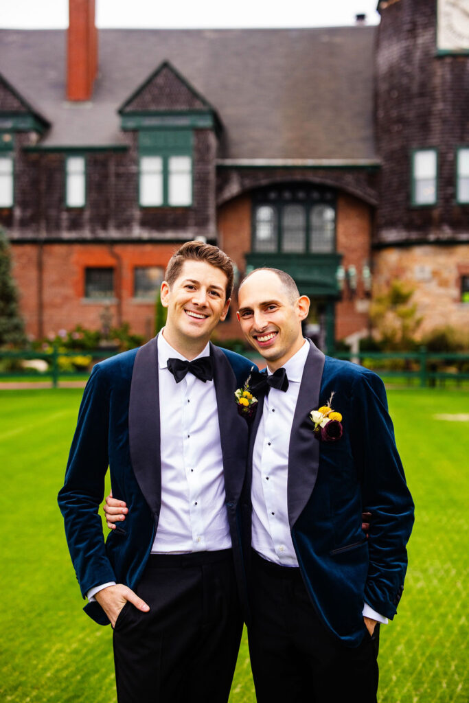 Grooms posing on the green at their Tennis Hall of Fame Wedding in Newport, Rhode Island