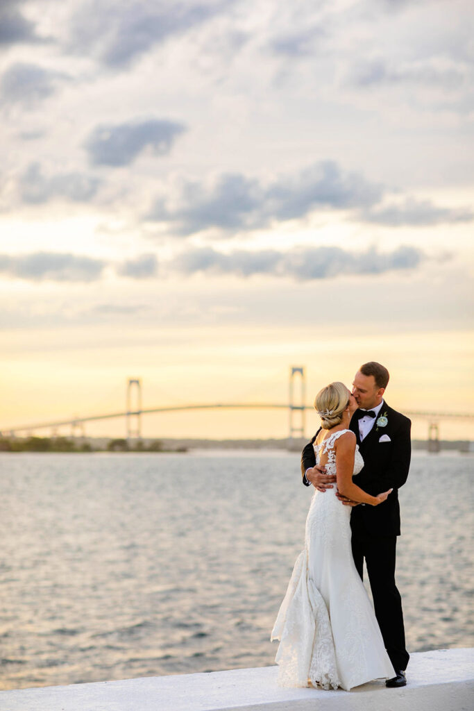 Bride and Groom taking formal photos on sunset by the water at Belle Mer Island House in Newport, RI.