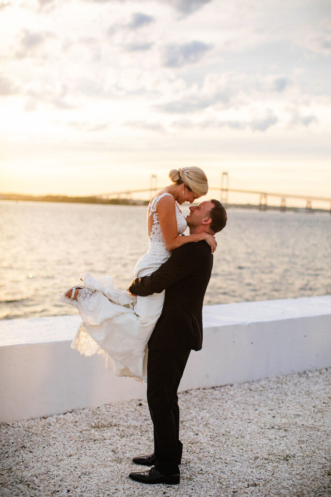 Bride and Groom taking formal photos on sunset by the water at Belle Mer Island House in Newport, RI.