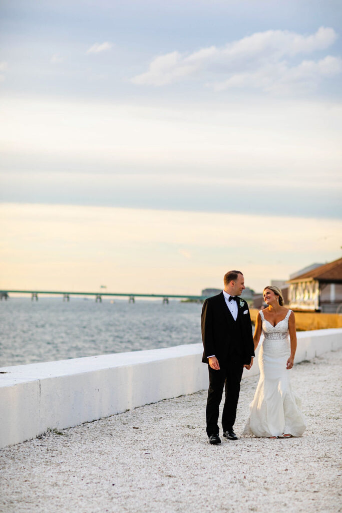 Bride and Groom taking formal photos on sunset by the water at Belle Mer Island House in Newport, RI.