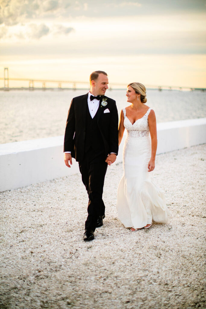 Bride and Groom taking formal photos on sunset by the water at Belle Mer Island House in Newport, RI.