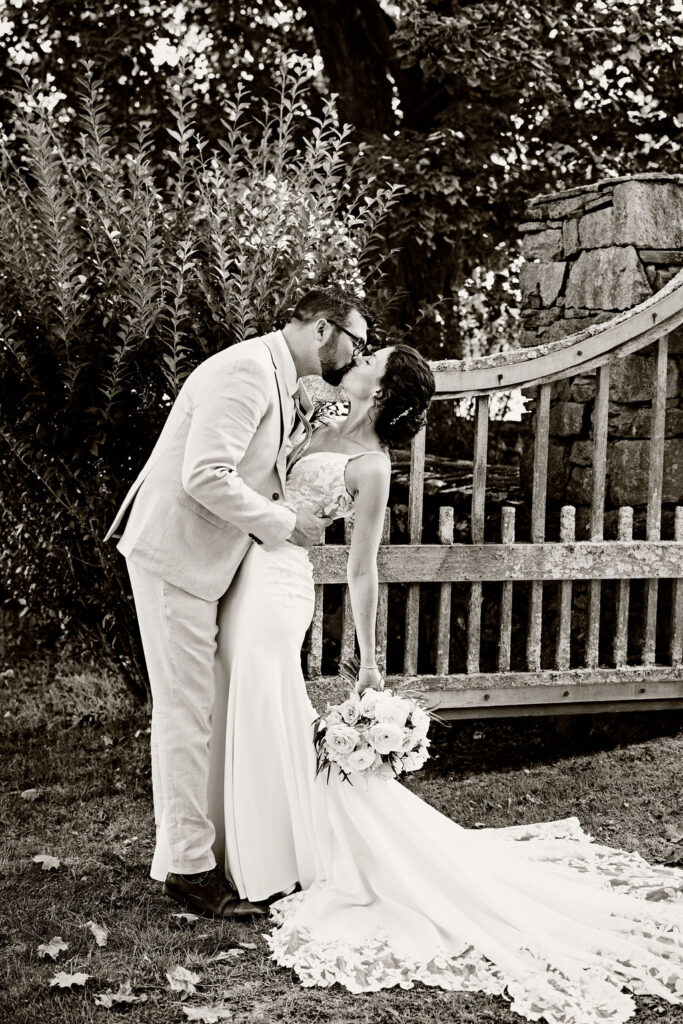 Bride and groom kissing by gates at Mount hope farm 