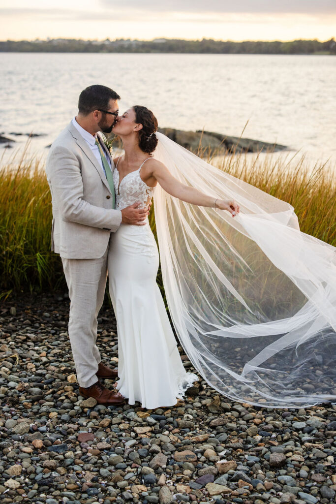 Sunset portraits of bride and groom by the water at Mount Hope Farm in Bristol