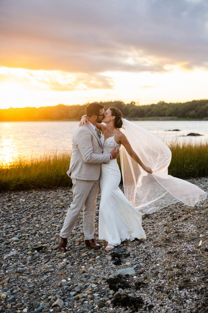Sunset portraits of bride and groom by the water at Mount Hope Farm in Bristol