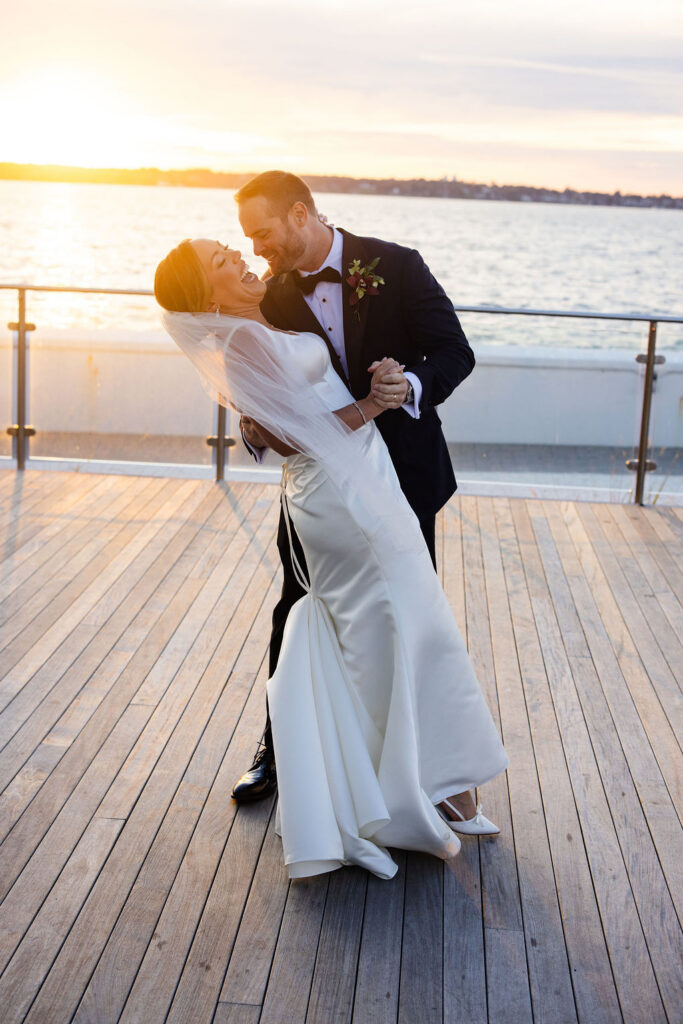 bride and groom post for photos at sunset at Newport Harbor Island Resort wedding
